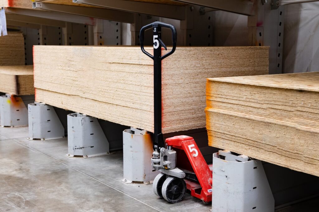 Delivery man with a hand truck loaded with boxes working in a warehouse