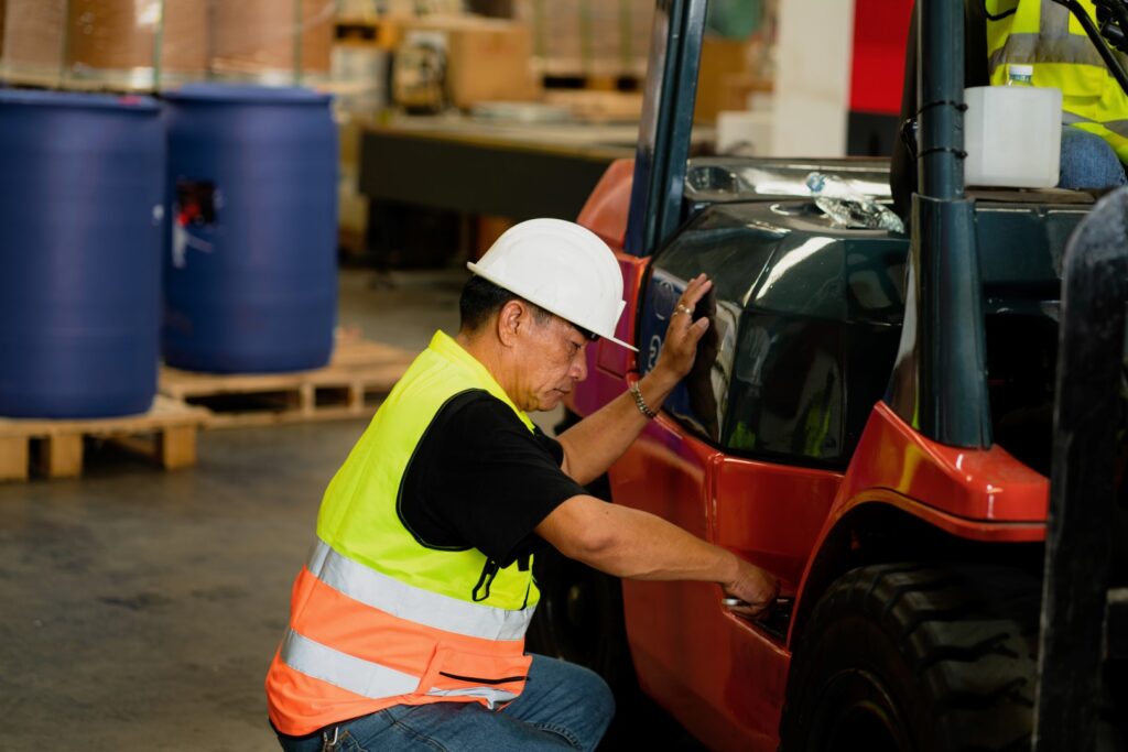 Warehouse worker doing logistics work with forklift loader.